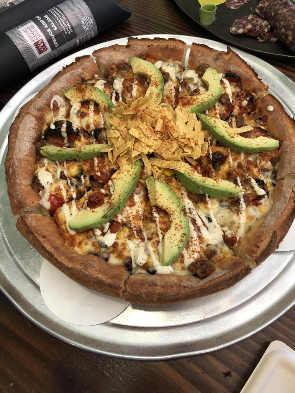 This deep dish pizza is topped with fresh California avocado slices. 