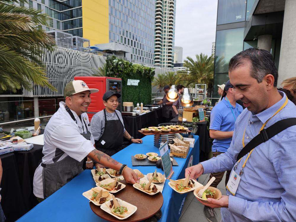 Chef Jason Hernandez speaking with a Del Taco representative during the Monday evening reception at the Flavor Experience Conference.