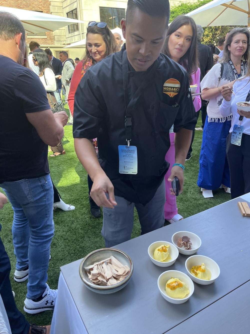 Attendee reaching for the California Avocado Ice Cream with Mango and Passionfruit. 