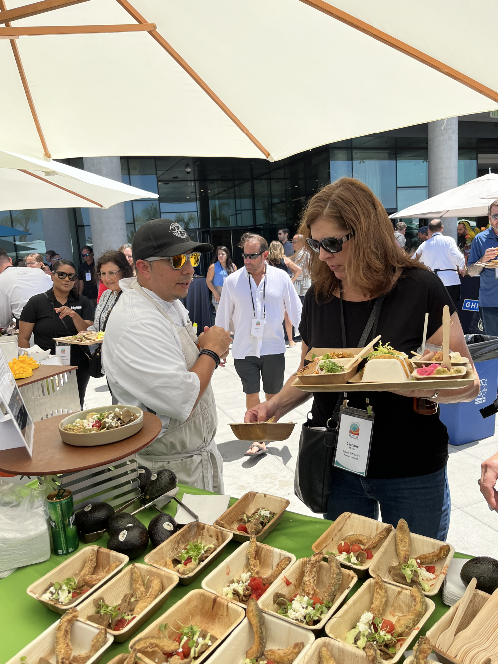 Chef Jason Hernandez describing the California Avocado Loaded Fries, Greek Style to an event attendee.